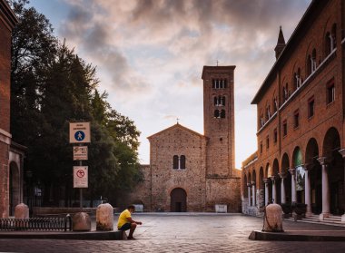 Ravenna, Emilia Romagna / İtalya - Ağustos 2020: San Francesco Bazilikası, Ravenna şafak vakti, güneş ışığı parlıyor, oturan kişi