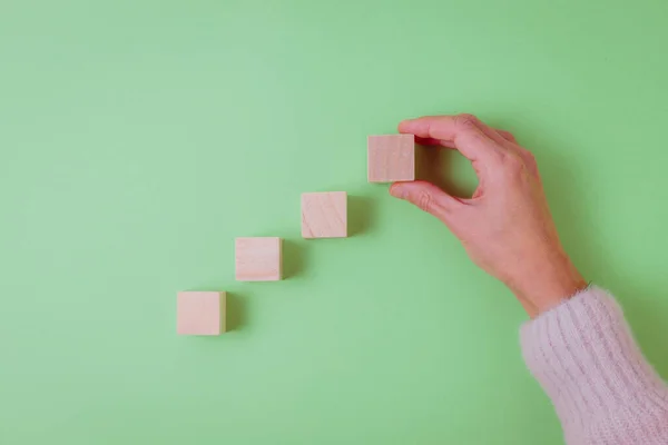 Primer Plano Mano Mujer Completando Serie Cubos Madera Fondo Verde —  Fotos de Stock