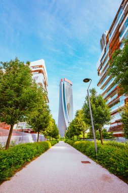 Milan, İtalya - Mayıs 2021: Milano 'nun CityLife semtinin modern apartmanları arasındaki garaj yolundan gökdelenlerin (üç kule) manzarası