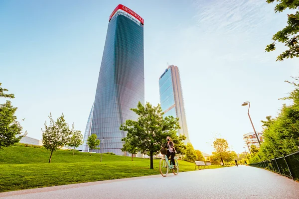 Milan, İtalya - Mayıs 2021: Arka planda modern gökdelenlerle Milano 'daki Şehir Hayatı Bölgesi Parkı' nda yürüyen kişi