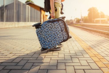 Milano, İtalya - 27 Mayıs 2023: Annesinin gün batımında treni beklerken kucağına aldığı bebek arabasının ayrıntıları