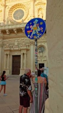 Lecce, Apulia, İtalya - 16 Ağustos 2025: Lecces eski kasabasındaki tarihi bir kilisenin dikey 4K görüntüsü, ılık yaz ışığı altında barok mimarinin altını çiziyor.