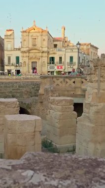 Lecce, Apulia, İtalya - 16 Ağustos 2025: Klasik bir güney İtalya şehir manzarası olan zarif barok binaların yer aldığı Lecces tarihi merkezinin dikey 4K görünümü