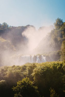 Marmore, İtalya - 19 Ağustos 2025: Kayalık kayalıklardan inen güçlü su taşması görülebilir sprey ve sis yaratıyor.
