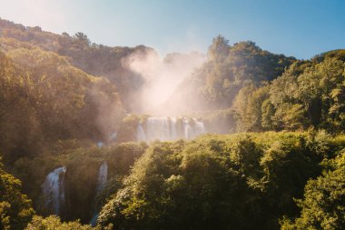 Marmore, İtalya - 19 Ağustos 2025: Sahne şelalesi yaz mevsiminde koyu yeşil yapraklarla kısmen gizlendi.