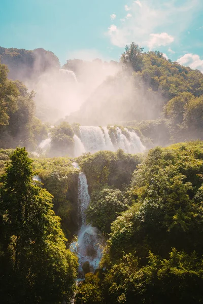 Marmore, İtalya - 19 Ağustos 2025: Sis ve şelaleden geçen güneş ışınları atmosferik ışık yaratıyor.