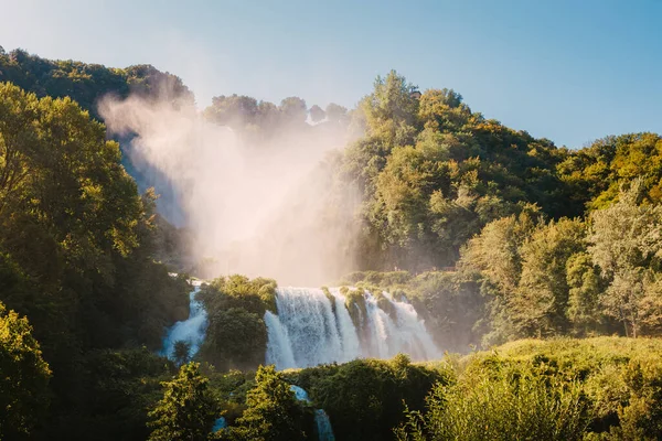 Marmore, İtalya - 19 Ağustos 2025: Yoğun yeşil ormanlık ve yaz atmosferiyle çevrili Marmore Şelaleleri geniş açı manzarası.