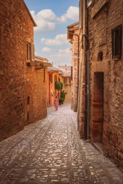 Spello, İtalya - 18 Ağustos 2025: Tarihi merkezde sıkışık bir taş geçidin samimi dikey görüntüsü, otantik Umbrian mimarisini yakalıyor.