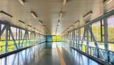 Mass Rapid Transit 'in (MRT) resmi, fayans yolundaki kör engeller için sarı dokunmatik asfalt döşeme ile üzerinden uçuyor.