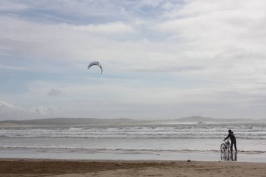 Çocuk plajda bisikletle oynuyor. Rahat bir ortamda okyanus dalgalarıyla.