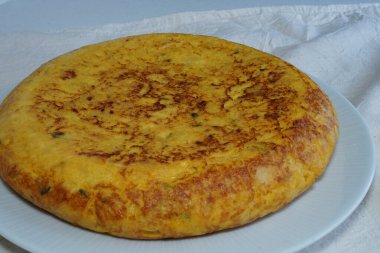 Beyaz masa örtülü patates tortillası.