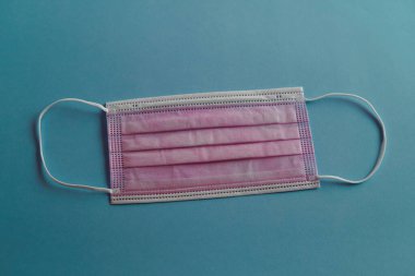 Mavi arka planlı pembe yüz maskesi