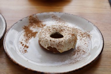 Beyaz tabakta beyaz kremalı havuçlu çörek.