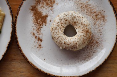 Beyaz tabakta beyaz kremalı havuçlu çörek.