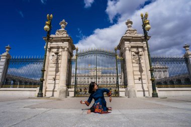 Sokaktaki kraliyet sarayıyla dans eden Asyalı kadın Vietnam 'dan geleneksel bir elbiseyle