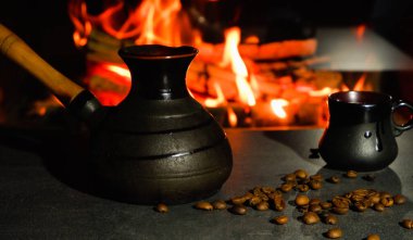 Yanan ateşin arka planında kahve çekirdekleri olan kahve fincanları. Türk kahvesi.