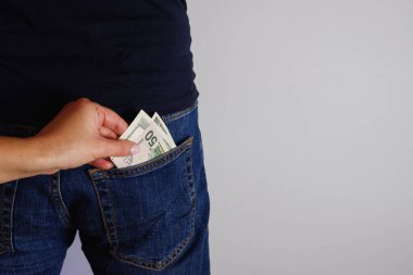 Kadın, ayakta duran adamın kot pantolonunun arka cebinden para çıkarıyor. Ellerin yakın görüntüsü. Metnin için yer.
