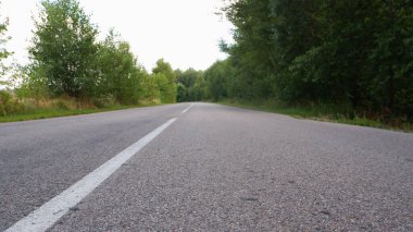 Asfalt gri yol yeşillikler arasında düşük plan