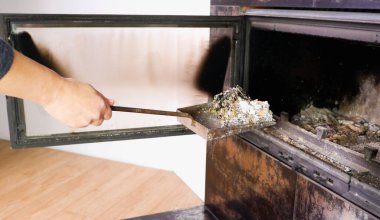 Şömine temizliği. Bir kadın kürekle kürek tutuyor. Bir el şöminenin küllerini eski çelik bir bıçakla topluyor. Günlük kış rutini