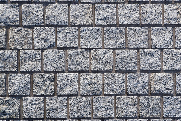 Gray, granite, square paving stones. Natural chipped stone.