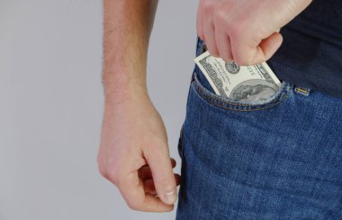 Adam kot pantolonun cebinden para çekiyor. Ellerin yakın görüntüsü. Metnin için yer.
