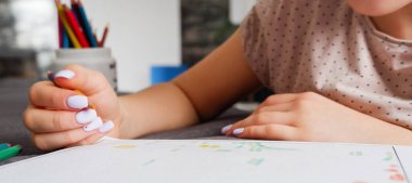 Kız çok renkli kalemlerle bir boyama yapıyor, yakın plan çekimde. Ev sanatı hobisi.