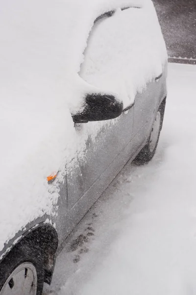 Snow blizzard with wind. Ice-covered passenger car covered with snow.