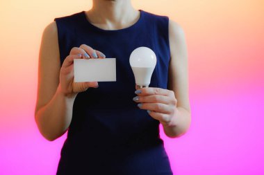 Bir kadın elinde bir ampul tutar. Fikir, yenilik ve ilham kavramı, kopya için arkaplan.