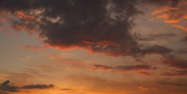 Gün batımında gökyüzü kötü havadan önce. Düşük kırmızı güneş ışığı gök gürültüsü bulutlarını aydınlatır.