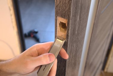 Kilidi tak ve iç kapıya sapla. Çalışma sürecinin yakın görüntüsü.