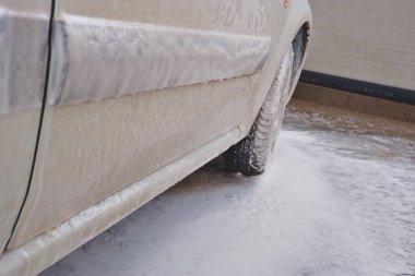 Yüksek basınçlı yıkama makinesi. Köpükle kaplı bir araç.