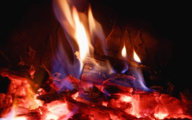 Şöminede cam kaplamalı ateş. Şöminede odun yanıyor.