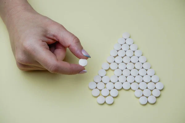 Las Manos Femeninas Doblan Pastillas Forma Corazón Sobre Fondo Amarillo — Foto de Stock