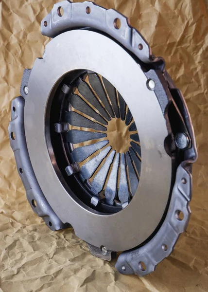 Passenger car clutch basket. Photo of a new clutch before installation on a car on a background of craft paper.