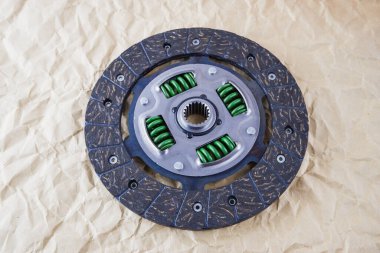 Araba parçaları. Araba debriyajı diski. Bir arabaya yerleştirmeden önce el işi kağıdının arka planına karşı yeni bir debriyaj diskinin fotoğrafı.