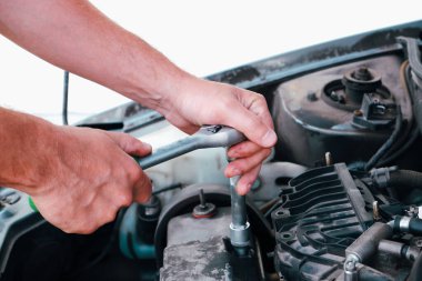 Araba tamiri. Tamirci tamirhanede araba motoru üzerinde çalışıyor. Tamir servisi. Yakın çekim.