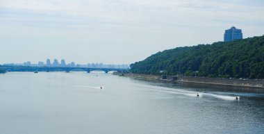 Manzara. Büyük bir şehrin ortasındaki derin bir nehrin manzarası. Ufukta toprak, plaj ve kentsel kalkınma görünüyor.