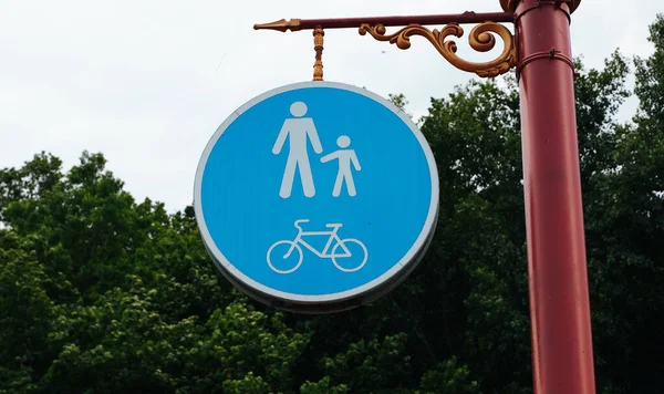 Road sign on the post. Walking and cycling area. Blue round traffic sign for safety. Bicycle and pedestrian lane road sign on pole post, blue