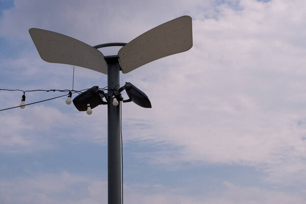 Modern park lighting pole with LED spotlights and reflectors.