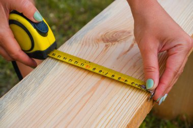 Kadın marangoz tahta bir tahtada kalem izi yapar. ÇEVİR.