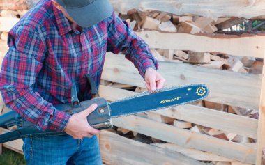 Elektrikli testere. Testere ve zincir testere. Yakın çekim. Zincirleme gerilimi kontrol ediyorum.