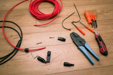 Güneş paneli kablo aletleri. Kablolar, konnektörler, ahşap zeminde kerpeten..