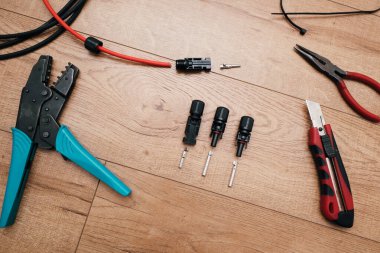 Güneş paneli kablo aletleri. Kablolar, konnektörler, ahşap zeminde kerpeten..