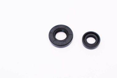 Beyaz zemin üzerinde iki farklı boyutta siyah kauçuk krank mili yağ mührü ya da contalar küçük bir çift zamanlı motor (örneğin, fırça kesici veya budayıcı) için izole edilmiştir. Yedek parçaları değiştir.