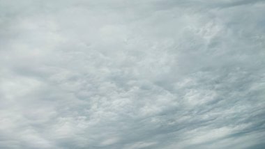 Dönen gri ve beyaz altostratların ya da sirokümülüs bulutlarının hakim olduğu donuk ve bulutlu bir gökyüzünün dramatik, tam kare görüntüsü. Ruh hali ağır, kötü hava ya da yaklaşan bir fırtına olduğunu gösteriyor..