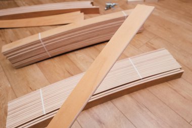 Ahşap bir zemine yerleştirilmiş birkaç hafif ahşap döşeme çatalının yukarıdan aşağı manzarası. Döşemeler DIY mobilya montaj projesinin bir parçası veya modern bir evdeki ev geliştirmesinin..