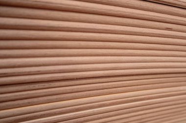 Çaprazlama dizilmiş pek çok paralel yuvarlak tahta kaplama ya da çıtanın arka plan dokusu. Mobilya imalatı ve marangozluk projeleri için doğal hafif ahşap malzeme.