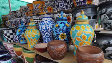 Shelves filled with painted ceramic pots with floral patterns