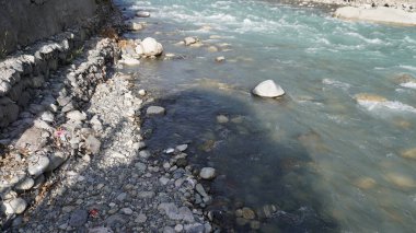 Turkuvaz beyazı suların kayalık arazide aktığı yüksek açılı dağ nehri, hızlı kavram..