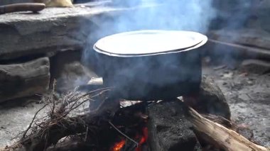 Kamp ateşinde pişen tencere.